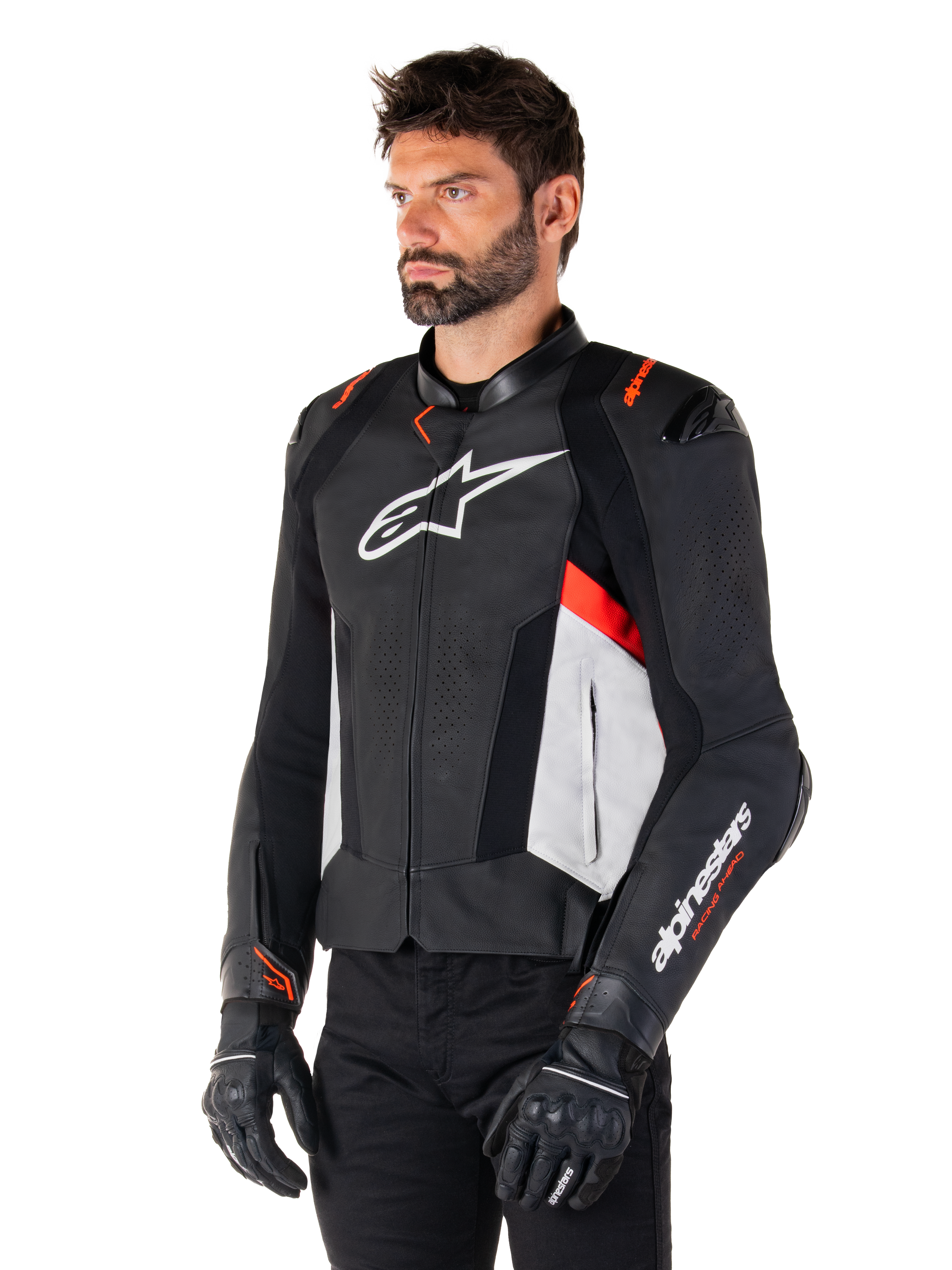 Veste en cuir Alpinestars Missile V3, noir, blanc et rouge fluo, veste de moto racing portée par un mannequin avec des gants et un pantalon noirs, dotée de panneaux en cuir perforé et d'un marquage Alpinestars distinctif