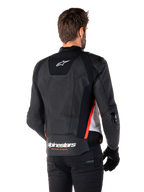 Veste en cuir Alpinestars Missile V3, vue de dos sur un motard, noir, blanc et rouge fluo, avec logo Alpinestars et texte « RACING AHEAD » au bas du dos, construction en cuir premium avec panneaux extensibles techniques et sliders de protection en TPU, portée avec des gants et un pantalon noirs.
