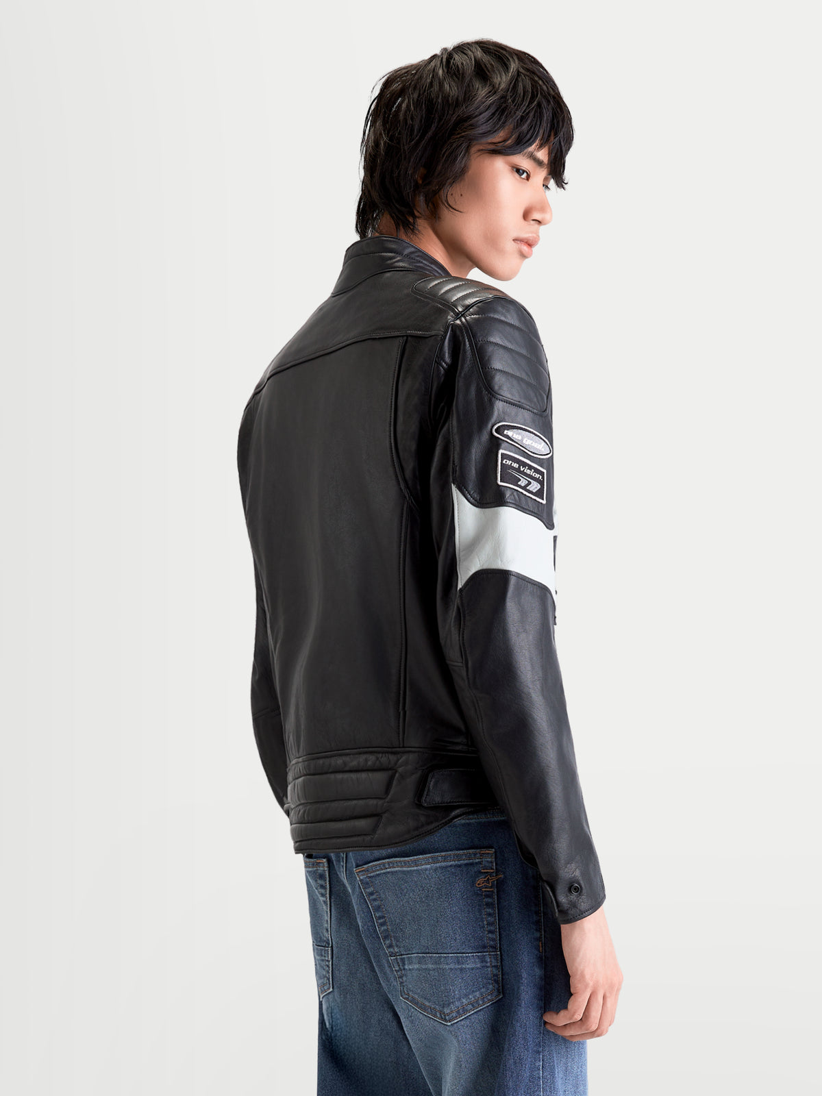 Alpinestars Revern Veste en cuir, blouson de moto urbain pour homme noir et gris métal, vue de dos sur un modèle portant du cuir de bovin pleine fleur avec des détails de marquage et une construction prête pour la protection
