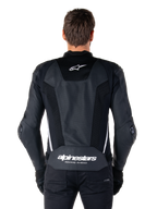 Veste en cuir Alpinestars Missile V3 Airflow, Noir et Blanc, vue de dos portée par un pilote, dotée de larges panneaux en cuir perforé, d'accents latéraux blancs, du logo étoile Alpinestars sur le haut du dos et du marquage « alpinestars RACING AHEAD » sur le bas du dos.