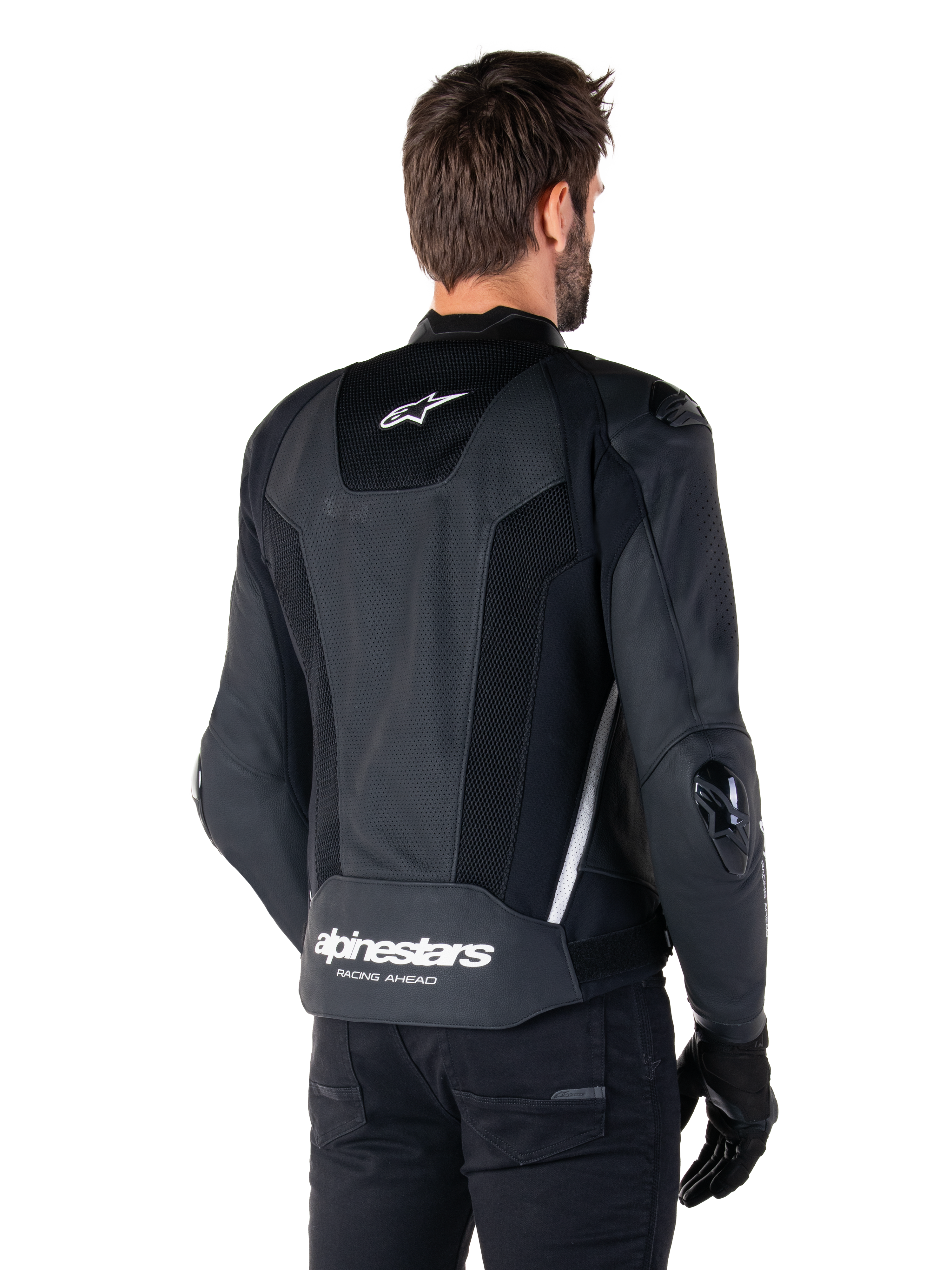Veste en cuir Alpinestars Missile V3 Airflow, noir et blanc, vue arrière avec cuir perforé et panneaux en mesh pour une ventilation maximale, logo Alpinestars blanc sur le bas du dos et logo étoile sur le col, portée avec un équipement de moto noir, design sportif haut de gamme.