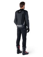 Veste en cuir Alpinestars Missile V3 Airflow, noir et blanc, vue de dos avec pantalon technique noir et bottes de course, panneaux arrière en cuir perforé et logo Alpinestars distinctif sur le bas du dos.