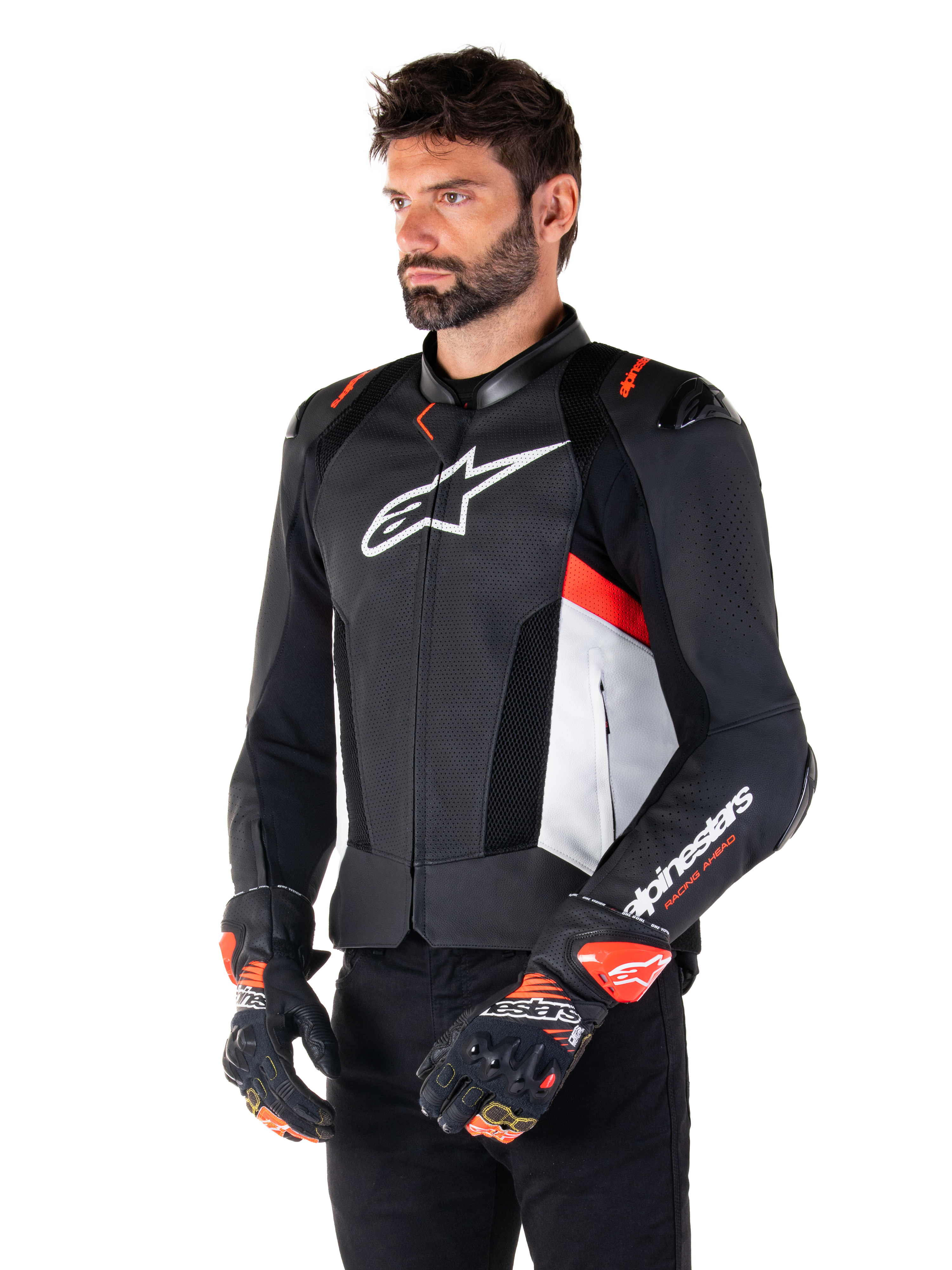 Veste en cuir Alpinestars Missile V3 Airflow, noir, blanc et rouge fluo, veste de moto racing sport, portée par un mannequin avec des gants assortis, avec panneaux en cuir perforé, grand logo blanc sur la poitrine et sliders d'épaule noirs.