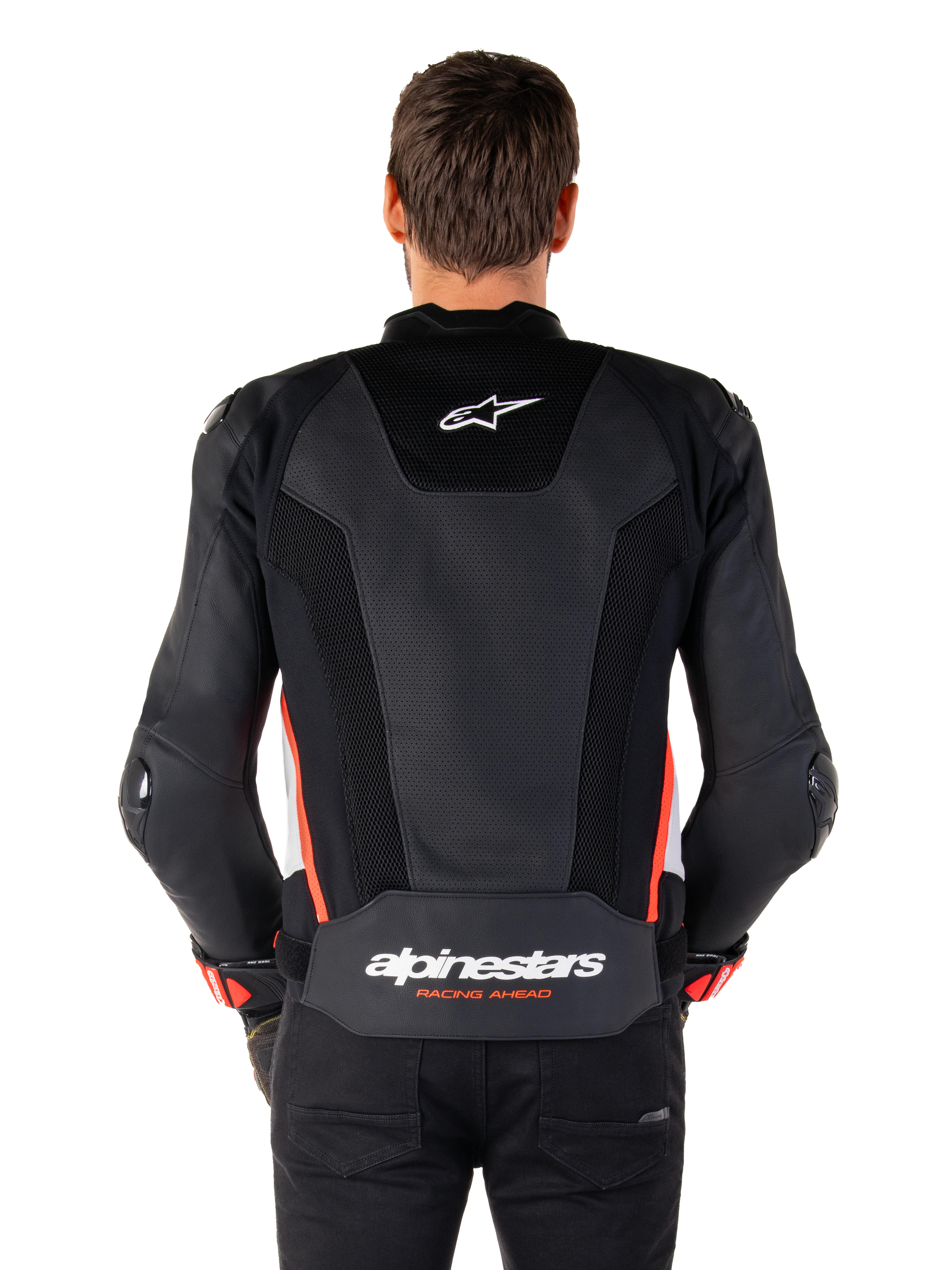 Vue arrière d'une personne portant la veste en cuir Alpinestars Missile V3 Airflow en Noir Blanc Rouge Fluo, dotée de larges panneaux en cuir perforé pour la ventilation, d'un petit logo Alpinestars sur le haut du dos et d'un marquage « alpinestars RACING AHEAD » imposant au bas de la taille.