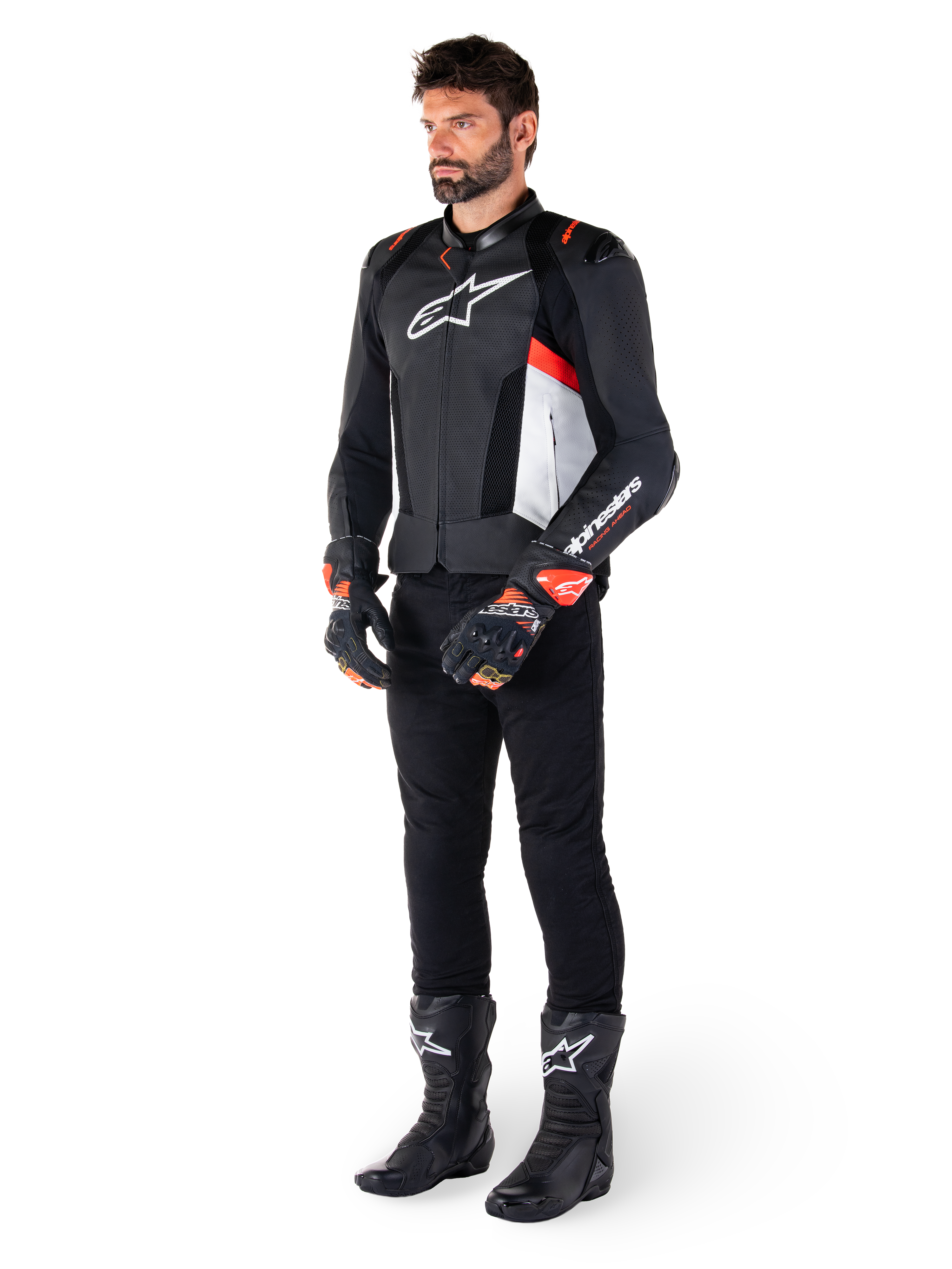 Veste en cuir Alpinestars Missile V3 Airflow, noir, blanc et rouge fluo, portée par un mannequin homme avec un pantalon noir, des gants de course noirs et des bottes noires, dotée de cuir perforé pour la ventilation, un logo blanc sur la poitrine et des accents rouge fluo, conçue pour une performance de course et de sport haut de gamme.