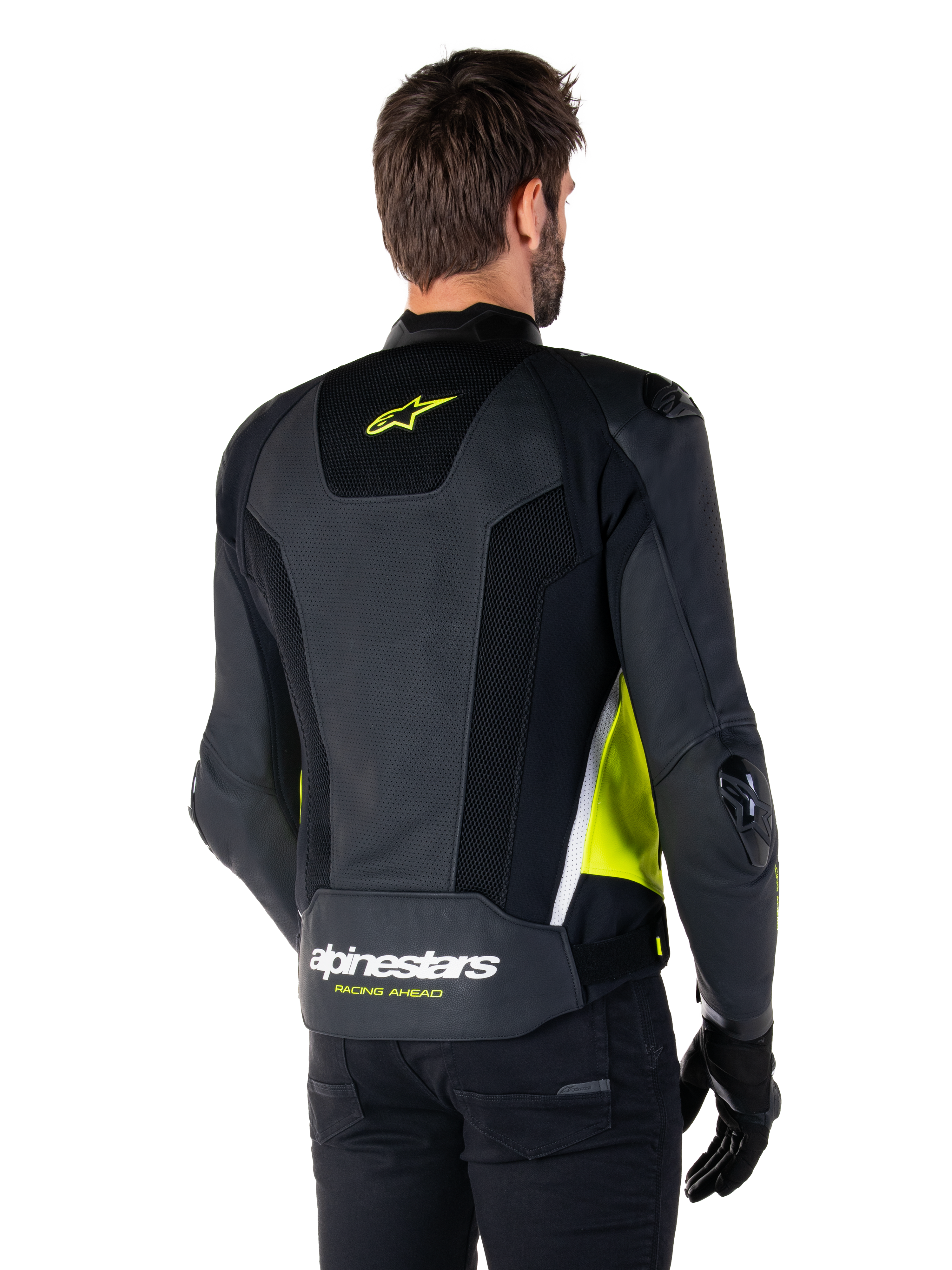 Veste en cuir Alpinestars Missile V3 Airflow, vue arrière sur un mannequin masculin, noire avec accents jaune fluo et blancs, dotée de larges panneaux en cuir perforé et en mesh sur le dos, arborant un logo étoile jaune et le texte blanc 'RACING AHEAD', accompagnée de gants et d'un pantalon noirs.