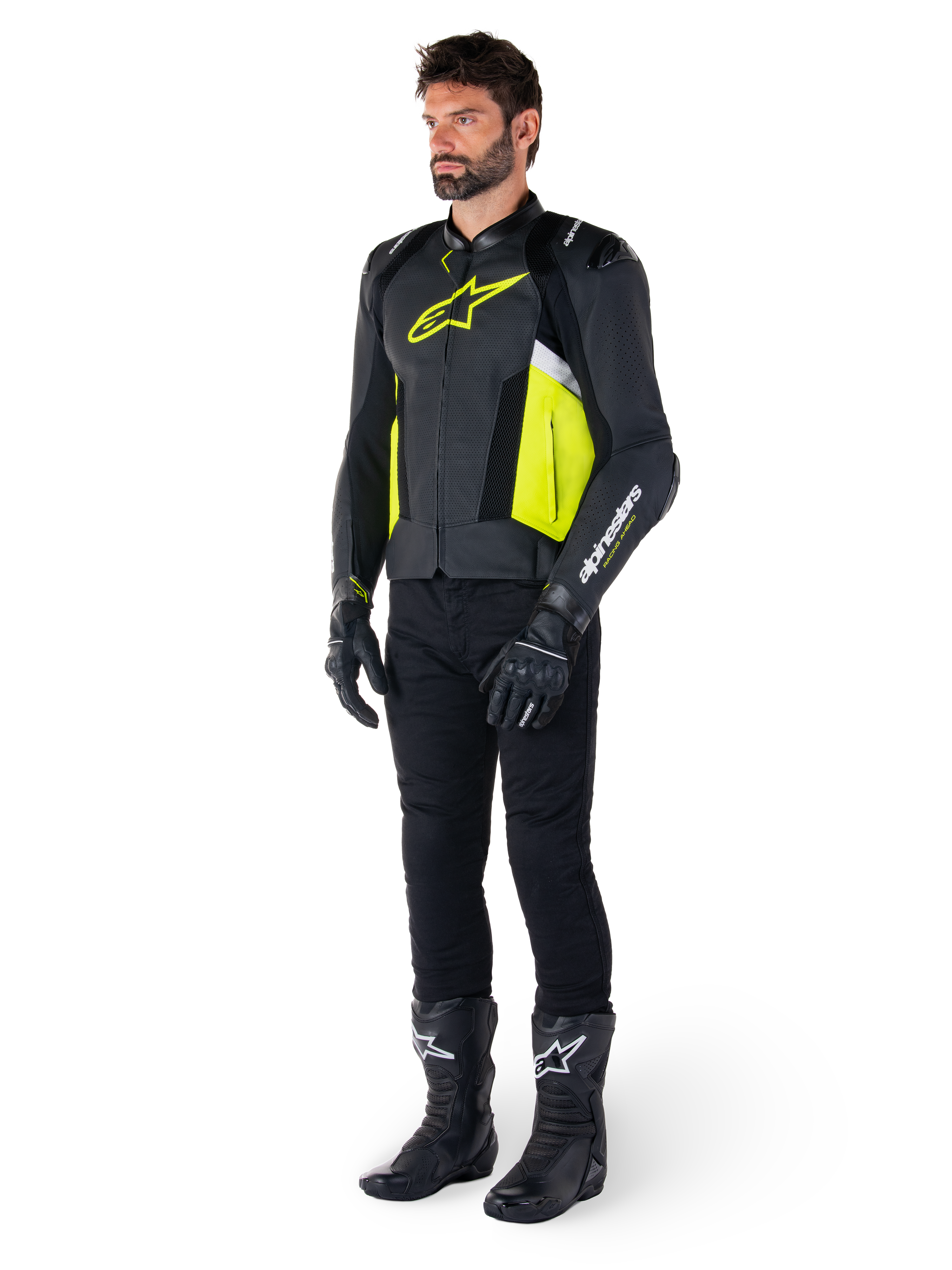 Modèle masculin portant la veste en cuir Alpinestars Missile V3 Airflow en noir, jaune fluo et blanc, associée à des gants, un pantalon et des bottes de moto noirs, mettant en valeur la conception en cuir perforé et l'esthétique inspirée de la course.