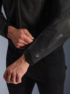 Veste en cuir Alpinestars GP Force V2, noir, vue rapprochée du poignet ergonomique, personne ajustant la fermeture du poignet, construction en cuir bovin haut de gamme avec des détails techniques pour la conduite de moto sportive