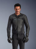 Alpinestars GP Force V2 Leather Jacket, noire et gris foncé, veste de course de moto, homme portant un design ajusté en cuir avec fermeture éclair frontale, associé à des gants texturés noirs, équipement de protection moderne, construction en cuir haut de gamme