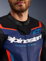 Blouson en cuir Alpinestars GP Force V2, vue détaillée de la poitrine et du col, bleu, noir et rouge fluo, avec logo Alpinestars blanc et inscription « RACING AHEAD » bleu clair, texture de cuir premium avec accents fluorescents