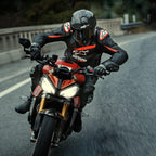 Motard sur une moto de sport rouge, veste en cuir Alpinestars GP Plus R V4 Rideknit, noir avec détails rouge fluo et blancs, logo Alpinestars blanc et texte 'ASTARS', casque et gants de course noirs, équipement de protection haute performance en action sur la route.