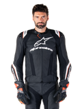 Veste en cuir Alpinestars Missile V3 Ignition, noire avec des accents blancs et rouges, portée par un mannequin homme avec gants et pantalon de course assortis, veste de moto sportive dérivée du MotoGP avec logo imposant