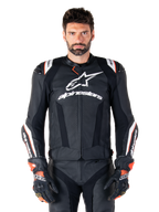 Veste en cuir Alpinestars Missile V3 Ignition, noire avec des accents blancs et rouges, portée par un mannequin homme avec gants et pantalon de course assortis, veste de moto sportive dérivée du MotoGP avec logo imposant