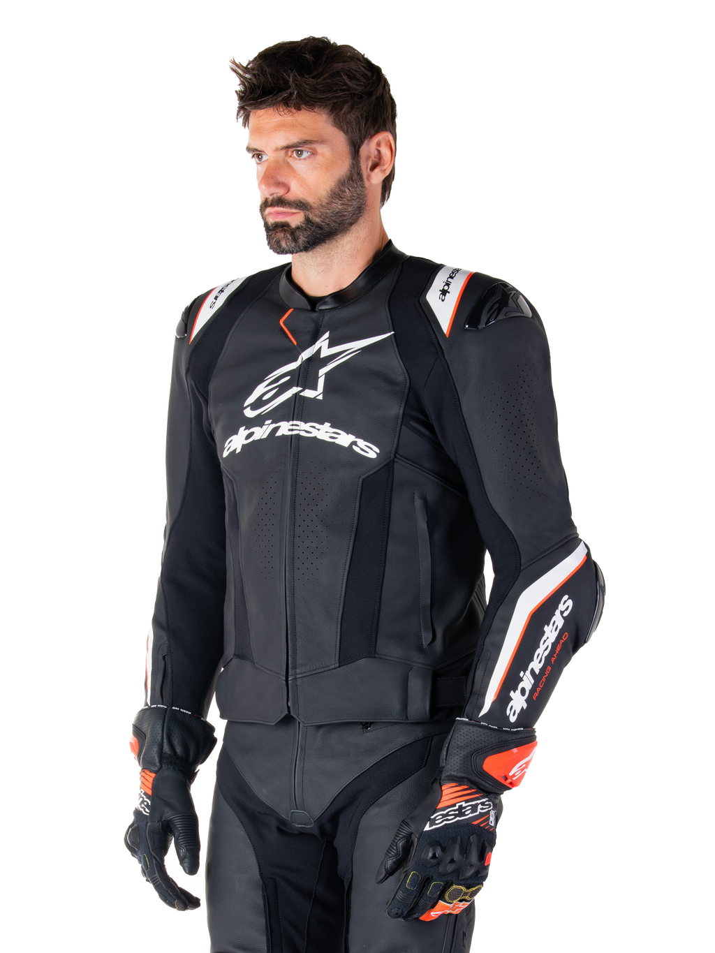 Modèle masculin portant la veste en cuir Alpinestars Missile V3 Ignition, noir avec des accents blancs et orange, dotée de logos blancs distinctifs, de sections en cuir perforé et de protections d'épaules, avec des gants de course pour un look sport-racing.