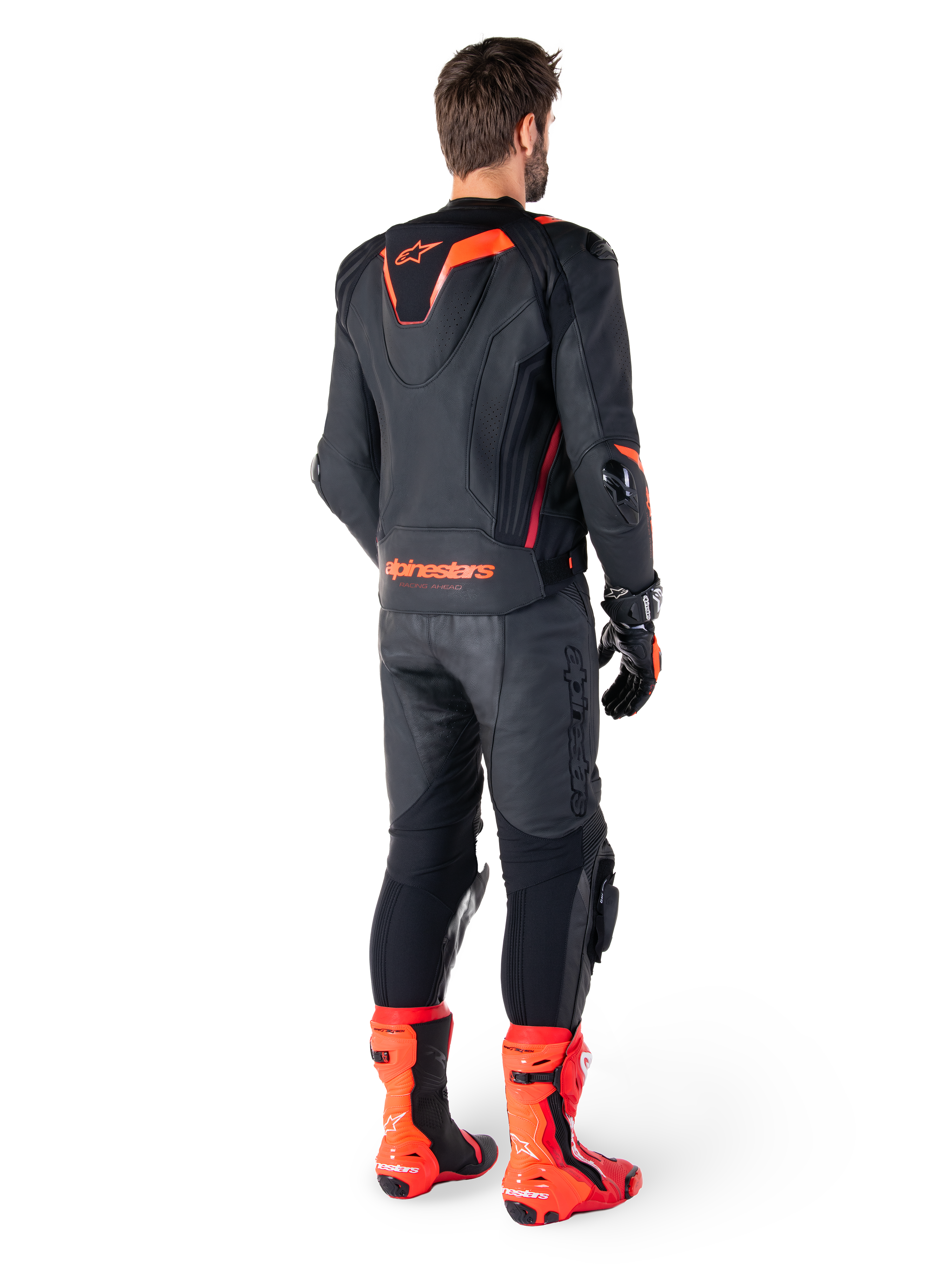 Alpinestars Missile V3 Ignition Leather Jacket, Racing Sport Motorcycle Jacket, Black and Red Fluo, rear view of a rider wearing a full racing outfit with matching leather pants, gloves, and red boots, featuring a sport Aero-hump and bold branding on the lower back.