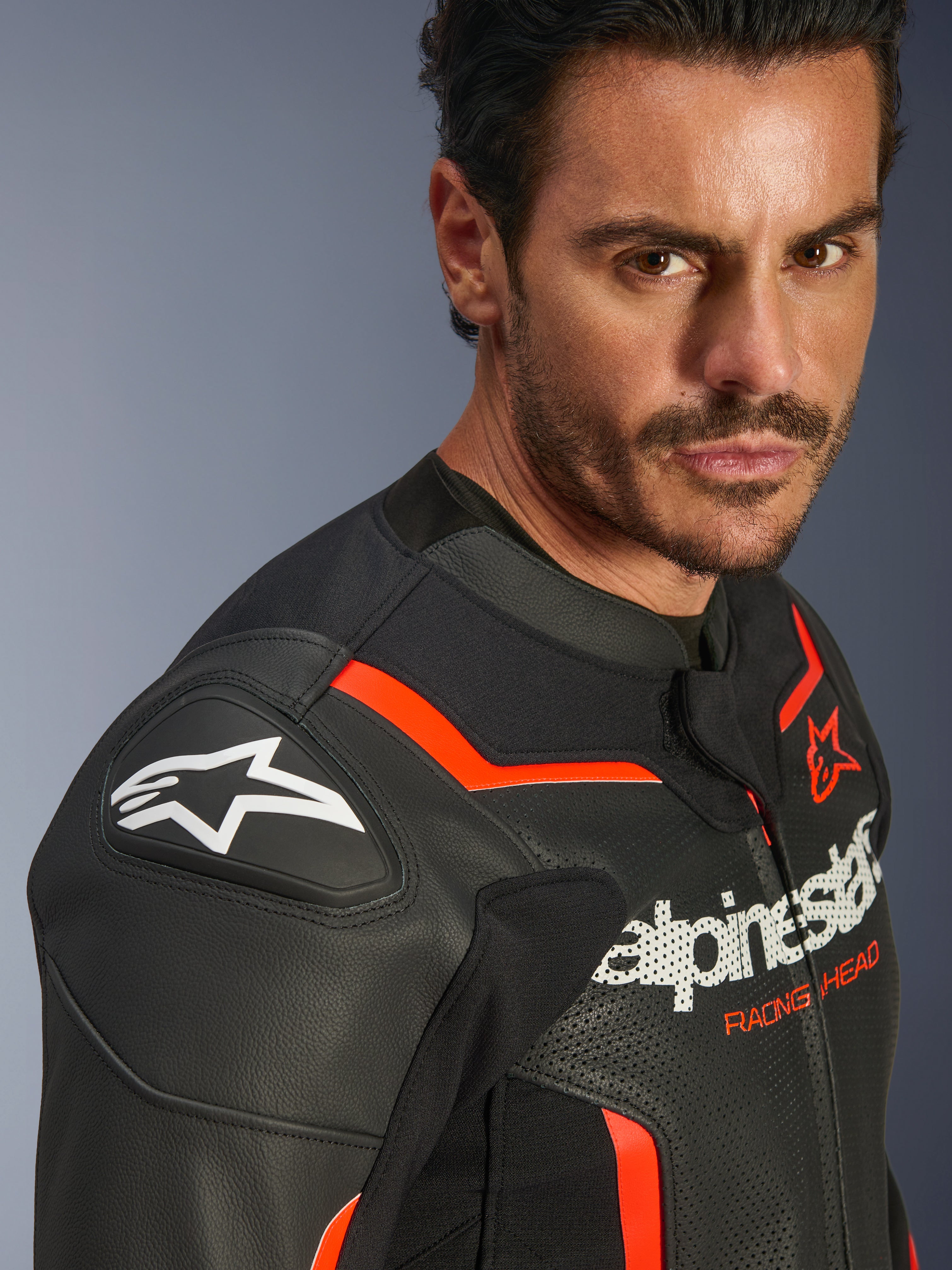 Blouson en cuir Alpinestars GP Force V2 Airflow, Noir Rouge Fluo, porté par un mannequin homme, avec cuir perforé, sliders d'épaule GP Lite Evo DFS et logo Alpinestars, équipement de protection pour moto sportive