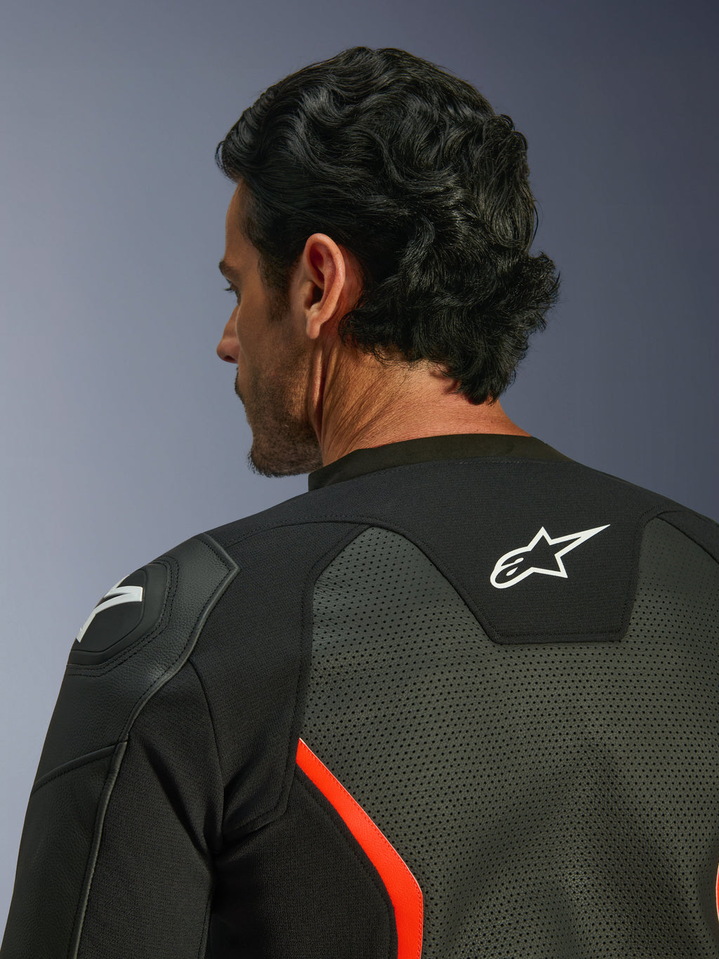 Blouson en cuir Alpinestars GP Force V2 Air, noir et rouge fluo, gros plan sur le haut du dos et l'épaule, présentant de larges perforations pour la circulation de l'air, logo blanc au dos et protection d'épaule GP Lite Evo