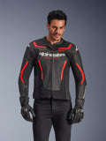 Blouson en cuir Alpinestars GP Force V2 Air, veste de moto de course, noir et rouge fluo, construction en cuir de qualité supérieure avec de larges perforations pour la circulation de l'air, porté par un mannequin avec gants et pantalon noirs, arborant un logo imposant et l'inscription 'Racing Ahead' sur la poitrine