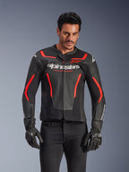 Blouson en cuir Alpinestars GP Force V2 Air, veste de moto de course, noir et rouge fluo, construction en cuir de qualité supérieure avec de larges perforations pour la circulation de l'air, porté par un mannequin avec gants et pantalon noirs, arborant un logo imposant et l'inscription 'Racing Ahead' sur la poitrine
