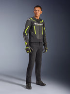 Mannequin homme portant la veste en cuir Alpinestars GP Force V2 Air en noir et jaune fluo, associée à un pantalon de moto noir, des gants assortis et des chaussures noires, photo de studio en pied d'équipement de moto sportive avec cuir perforé et logos distinctifs