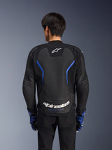 Blouson en cuir Alpinestars GP Force V2 Airflow, Noir Bleu Métallisé, vue arrière, doté d'un grand panneau perforé pour la ventilation, d'accents bleus et du logo Alpinestars blanc, porté avec des gants bleus assortis et un pantalon noir pour la conduite sportive.
