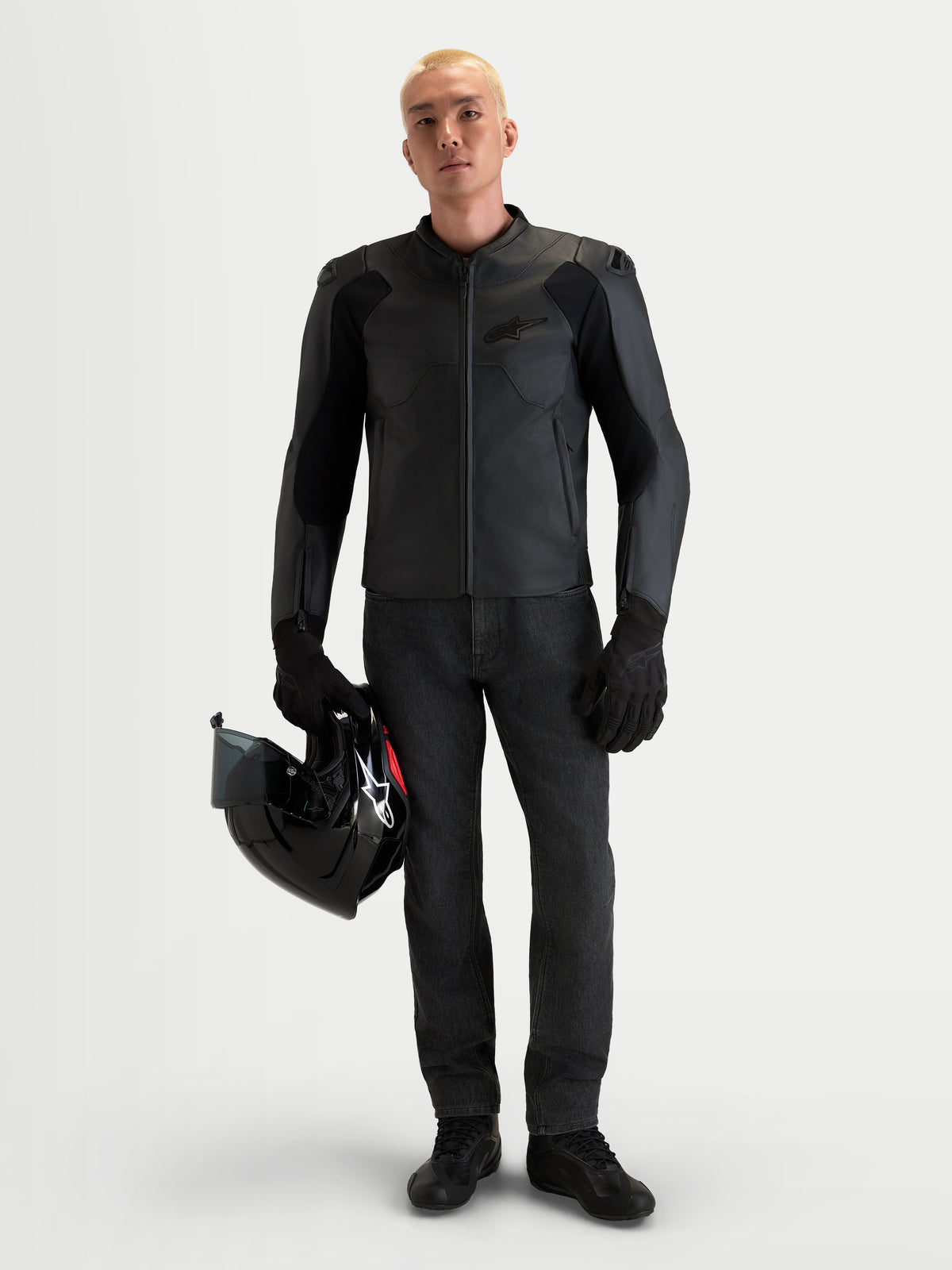 Alpinestars Caliber V2 Leather Jacket, Men's Black motorcycle leather jacket featuring AA-rated protection, low-profile DFS shoulders, and a full-grain bovine leather construction worn by a male model holding a black helmet