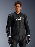 Alpinestars Dusk Leather Jacket, Black and White, leather motorcycle jacket with padded protection areas and white logos, worn with black and white racing gloves featuring red accents, professional sport riding gear
