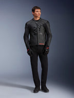 Veste en cuir Alpinestars GP Plus R V4 Airflow, noire, portée par un mannequin homme avec gants et pantalon noirs assortis, avec panneaux en cuir perforé, grand logo étoile ton sur ton sur la poitrine et coupe sport ajustée