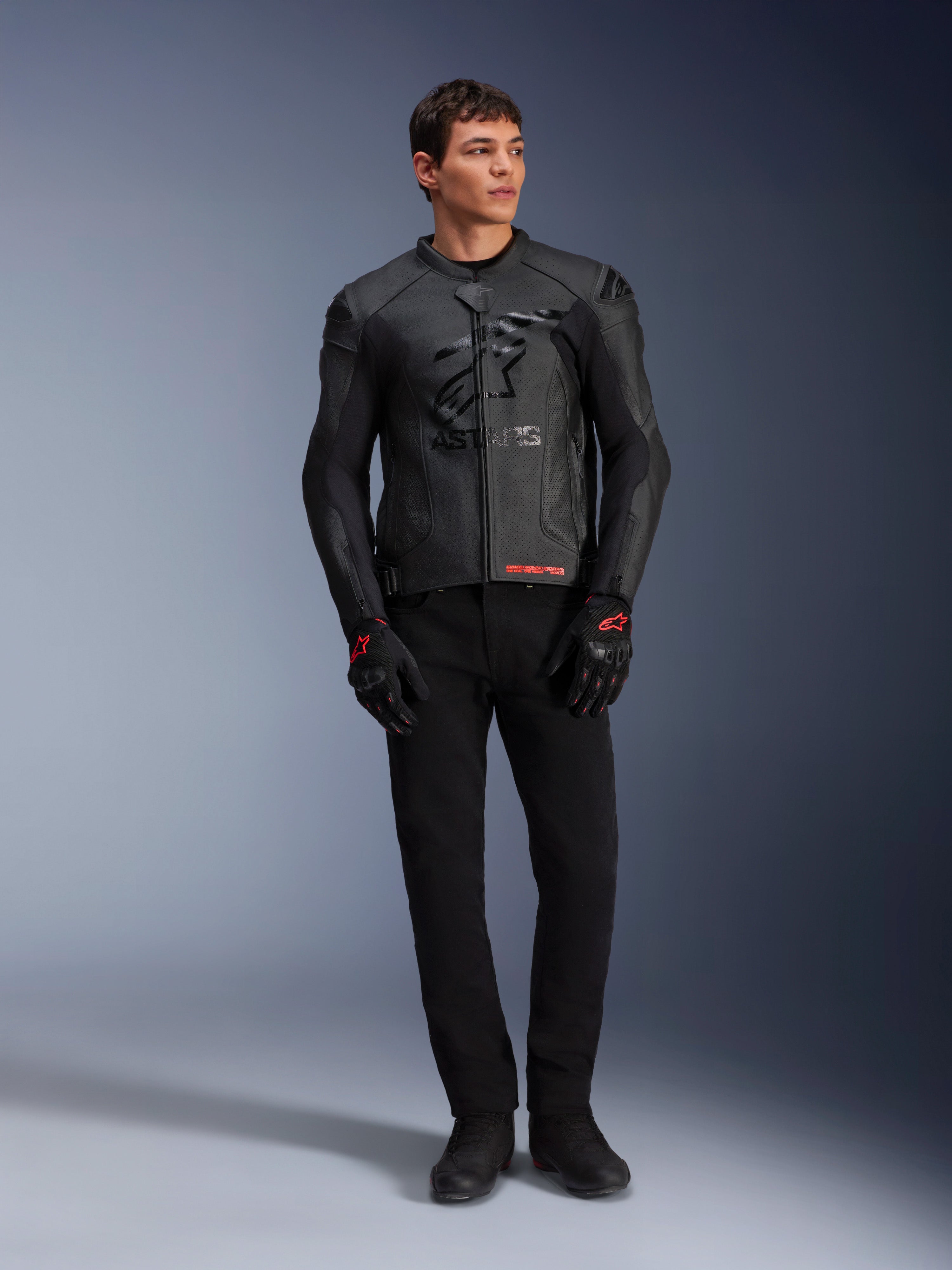 Veste en cuir Alpinestars GP Plus R V4 Airflow, noire, portée par un mannequin homme avec gants et pantalon noirs assortis, avec panneaux en cuir perforé, grand logo étoile ton sur ton sur la poitrine et coupe sport ajustée