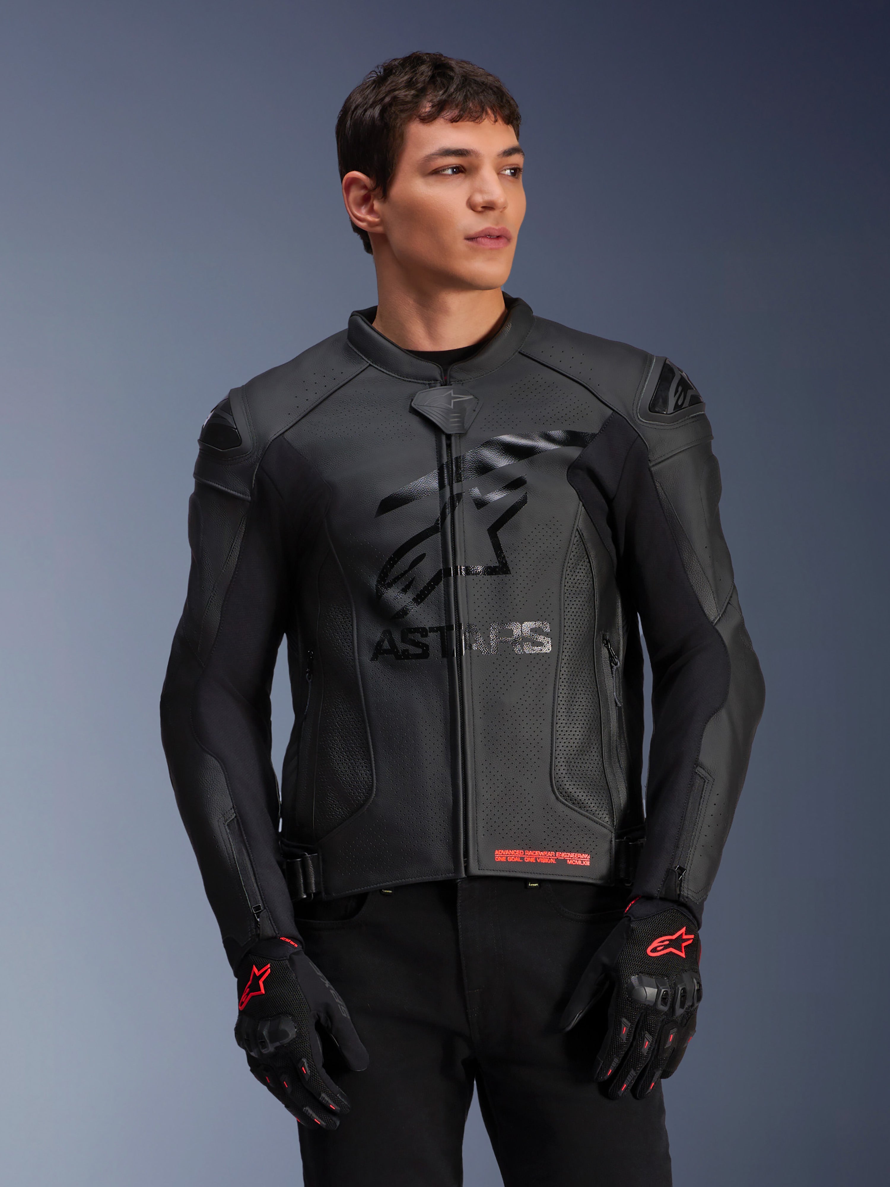 Alpinestars GP Plus R V4 Airflow, blouson de course moto en cuir, noir, construction en cuir perforé avec logo ASTARS sur la poitrine et protections d'épaules DFS, porté avec des gants noirs et rouges
