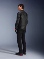 Veste en cuir Alpinestars GP Plus R V4 Airflow, veste de moto sport pour homme, entièrement noire, vue arrière de trois-quarts sur un mannequin, avec panneaux en cuir perforé, logo rouge dans le dos et protections d'épaules intégrées, portée avec un pantalon noir et des chaussures de moto