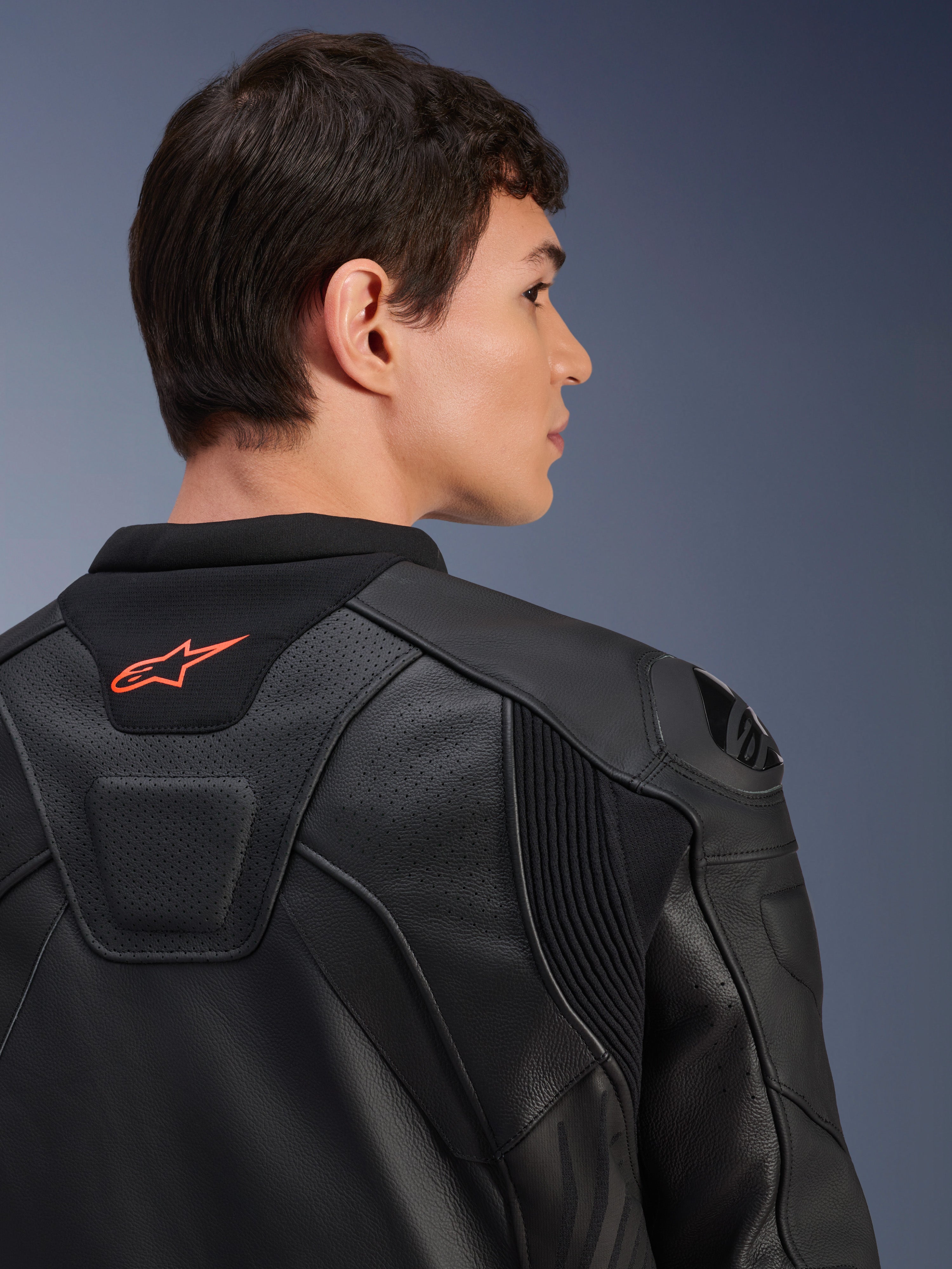 Veste en cuir Alpinestars GP Plus R V4 Airflow, noire, vue arrière rapprochée sur un modèle, avec cuir perforé de qualité course, panneaux stretch techniques et petit logo Alpinestars orange sur le col, équipement de moto professionnel