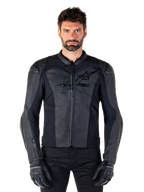 Veste en cuir Alpinestars Faster V3, blouson de moto noir, cuir haut de gamme avec panneaux extensibles HRSF, coupe sport élégante, épaules renforcées avec protections, porté avec des gants noirs, équipement professionnel pour la conduite sur route