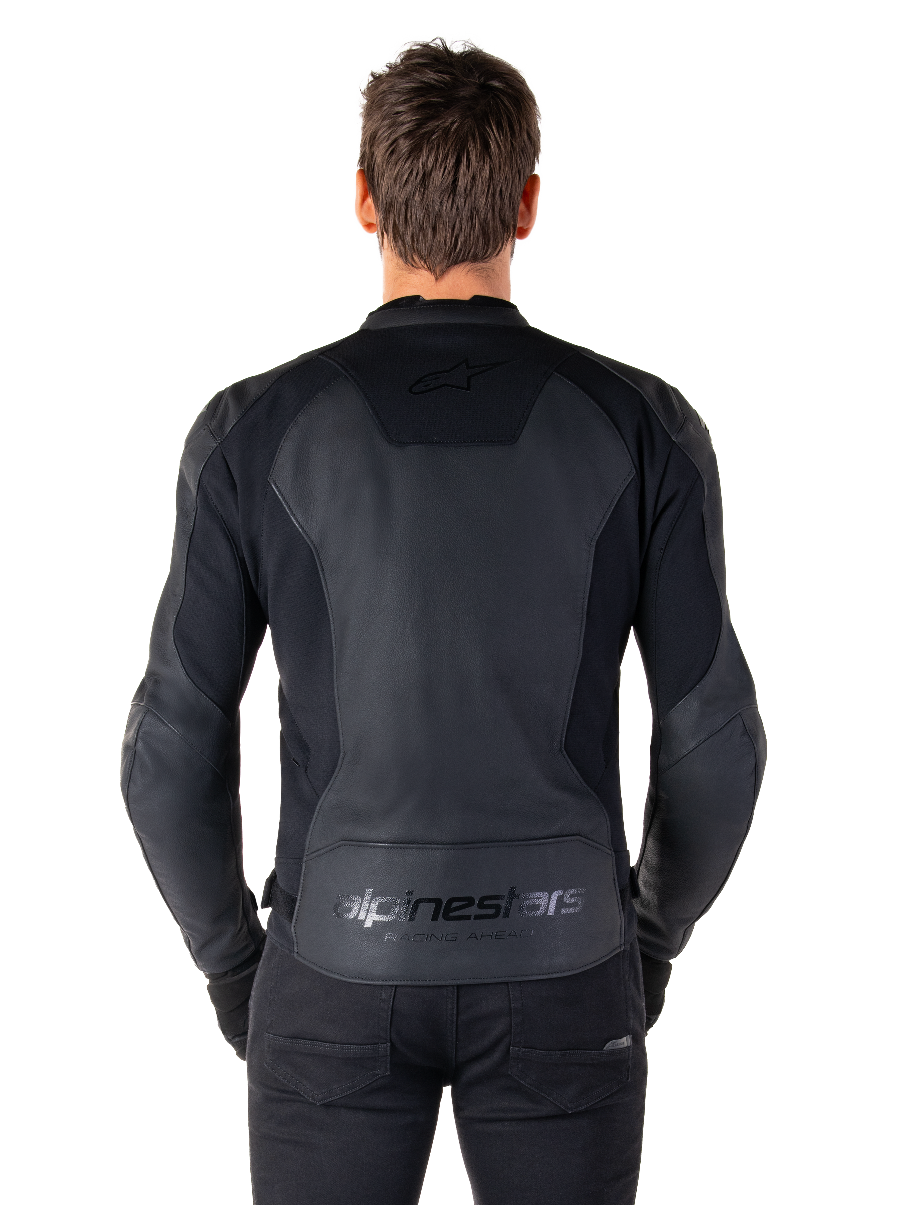 Vue arrière d'un homme portant la veste en cuir Alpinestars Faster V3 en Black Black, dotée de panneaux en cuir haut de gamme et d'empiècements extensibles, marquages discrets « alpinestars » et « RACING AHEAD » dans le bas du dos, coupe sport athlétique pour la moto.