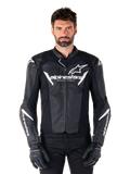 Veste en cuir Alpinestars Faster V3, veste de moto de course noire et blanche, avec logos blancs imposants et texte « Racing Ahead » sur la poitrine, design en cuir épuré avec détails angulaires sur les manches, portée avec des gants de course noirs