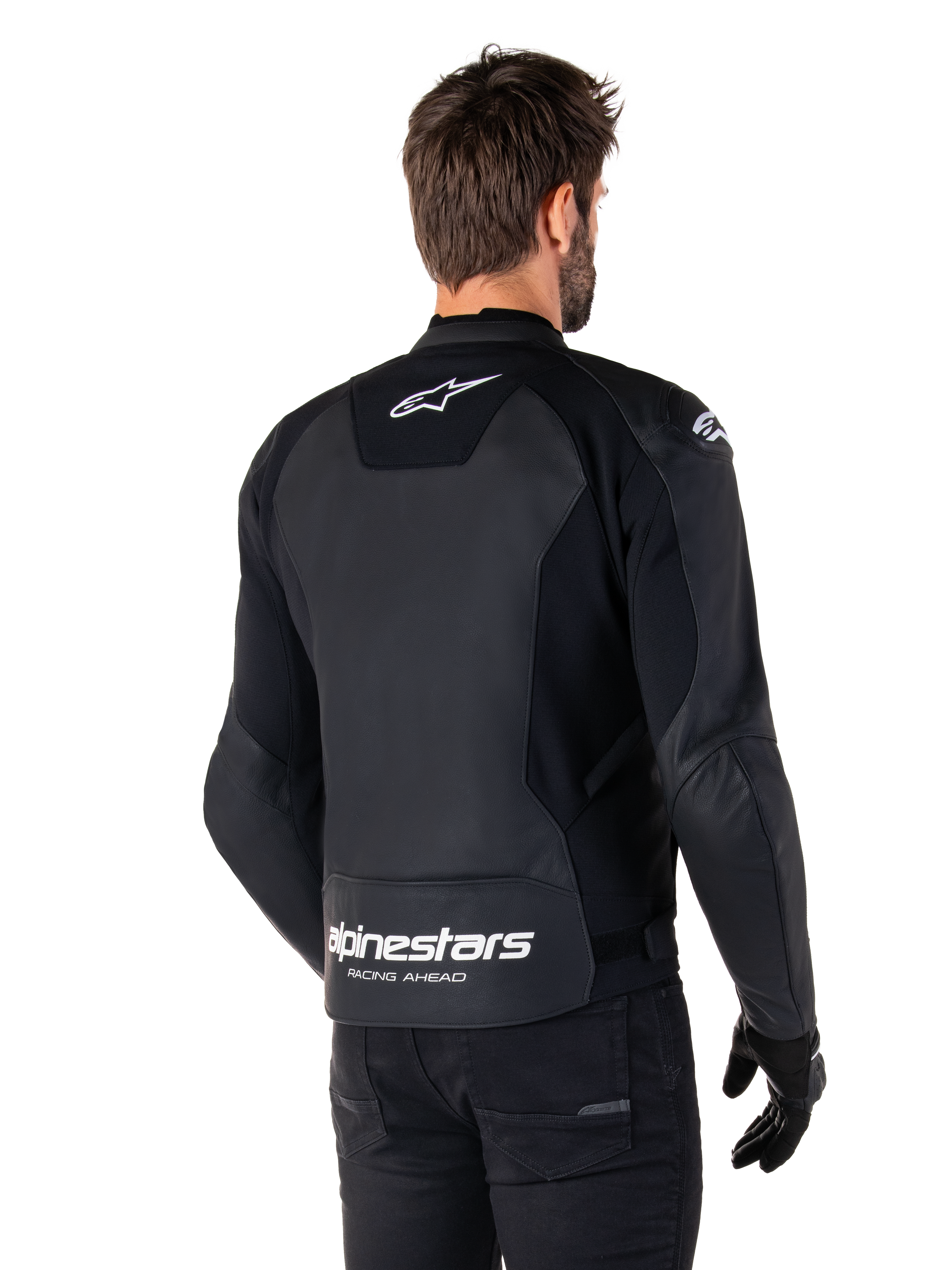 Veste en cuir Alpinestars Faster V3, noir et blanc, vue arrière sur un pilote, avec logo étoile blanc sur le haut du dos et grand marquage Alpinestars avec « Racing Ahead » sur le bas du dos, dos allongé pour une meilleure couverture, construction en cuir sport haut de gamme