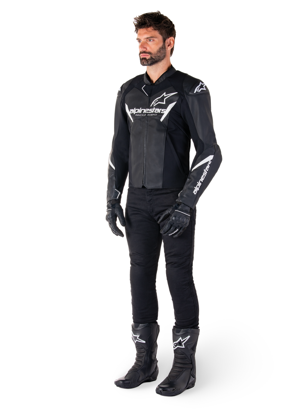Mannequin masculin portant la veste en cuir Alpinestars Faster V3, veste de moto sport noir et blanc, associée à un pantalon, des gants et des bottes de moto noirs, avec logos et marquages blancs, coupe sport pour la course sur route