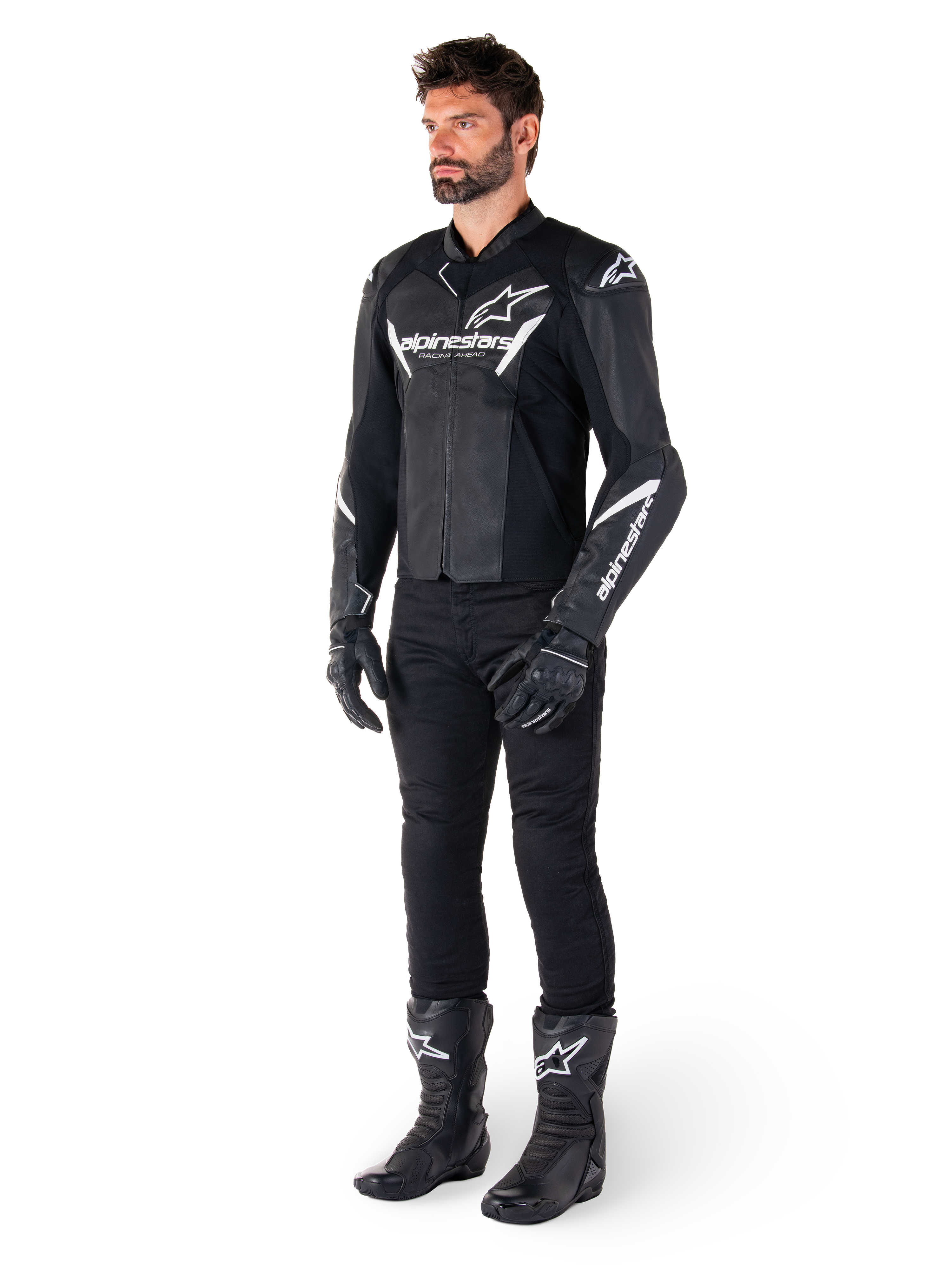 Mannequin masculin portant la veste en cuir Alpinestars Faster V3, veste de moto sport noir et blanc, associée à un pantalon, des gants et des bottes de moto noirs, avec logos et marquages blancs, coupe sport pour la course sur route