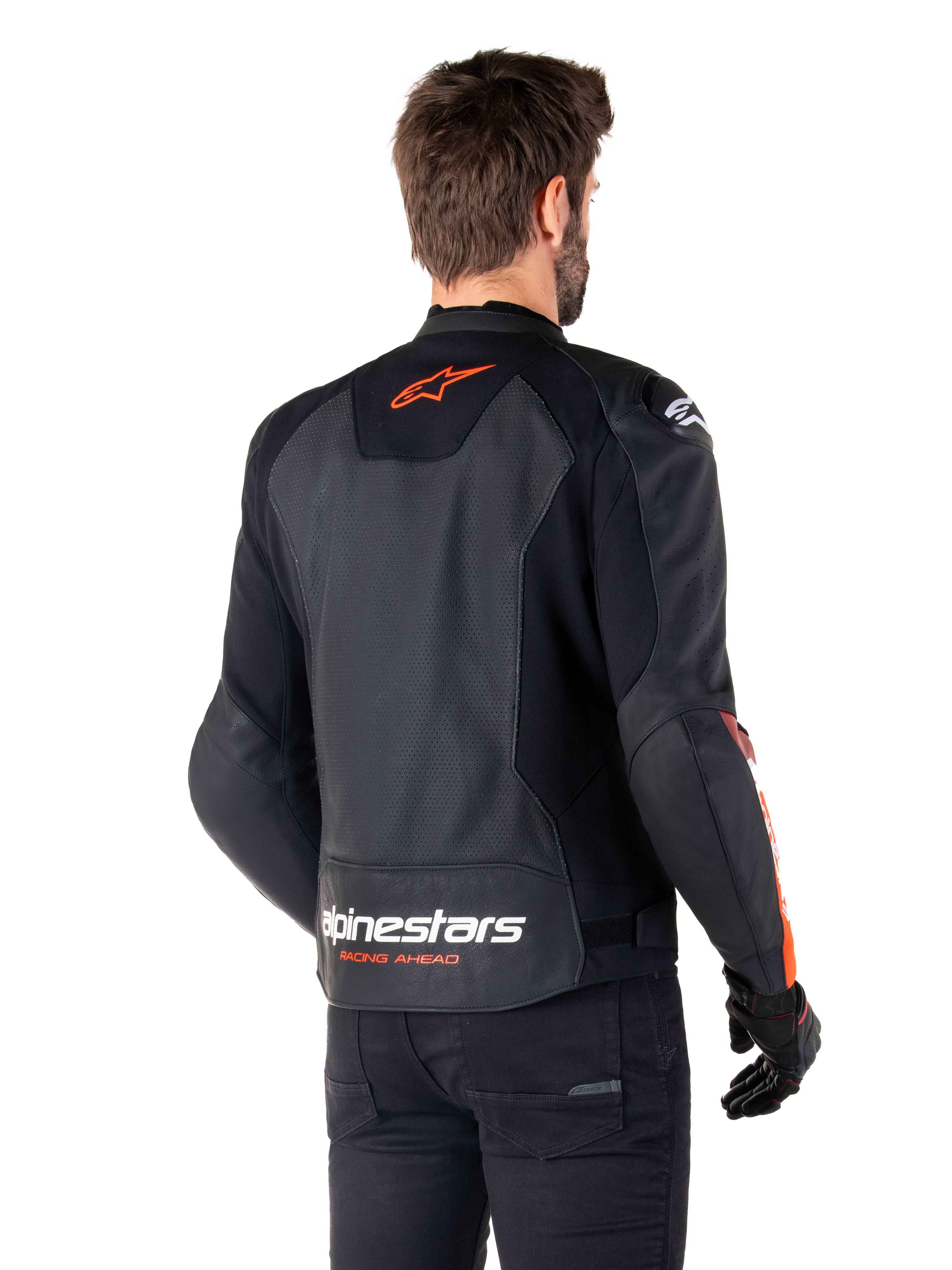Veste en cuir Alpinestars Faster V3 Airflow, veste de moto sportive, noir et rouge fluo, vue de dos, avec panneaux en cuir perforé, logo Alpinestars rouge-orangé sur le haut du dos et marquage blanc sur le bas du dos, portée avec un pantalon et des gants noirs, style épuré dérivé de la course