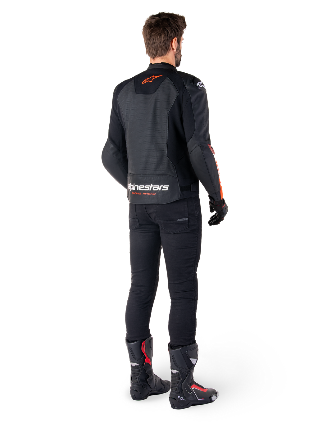 Veste en cuir Alpinestars Faster V3 Airflow, noir et rouge fluo, vue de dos sur un pilote, avec des panneaux en cuir perforé et un marquage distinctif, portée avec un pantalon noir et des bottes de moto, tenue de pilotage sportive.