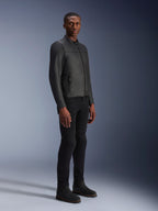 Modèle masculin portant la veste en cuir Alpinestars Blacktrack, noir sur noir, style motard moderne avec cuir premium et détails de zips métalliques, associé à un pantalon et des bottes noirs pour un look urbain contemporain