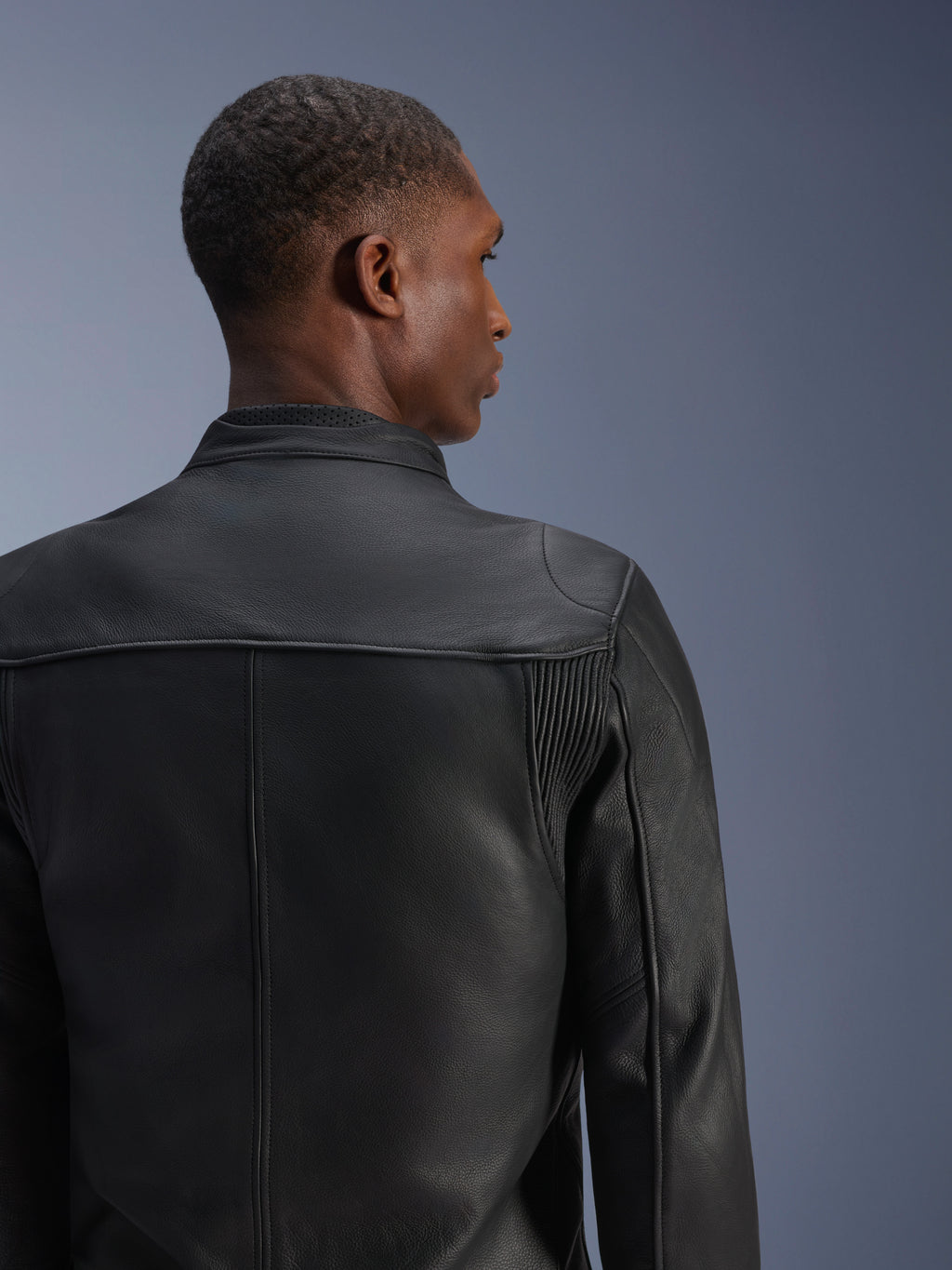 Veste en cuir Alpinestars Blacktrack, noire, veste de moto en cuir de bovin premium vue de dos, dotée de panneaux en accordéon en cuir sur les omoplates et d'un col perforé, coupe ajustée pour la conduite urbaine