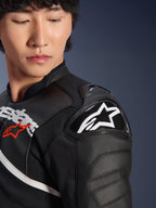 Gros plan sur la veste en cuir Alpinestars Atem V5 en noir et blanc, présentant la protection d'épaule DFS RR avec logo étoile blanc, une construction en cuir perforé et des graphismes sur la poitrine inspirés de la course.