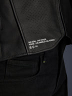 Gros plan sur la veste en cuir Alpinestars Atem V5 en noir, présentant le panneau inférieur du dos avec le marquage « ONE GOAL. ONE VISION. VENICE / LOS ANGELES CALIFORNIA » et une texture en cuir perforé.