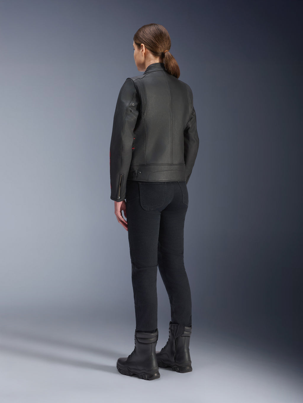 Veste en cuir Alpinestars Stella Dyno, veste de moto pour femme, Noir Haute Red, vue arrière, portée avec un pantalon de moto noir et des bottes noires, finition en cuir de première qualité au style héritage