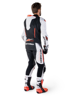 Alpinestars GP-R7, combinaison en cuir de course pour homme, blanche et noire, avec bosse aérodynamique, Tech-Air ready, vue de dos sur un pilote avec bottes et gants professionnels.