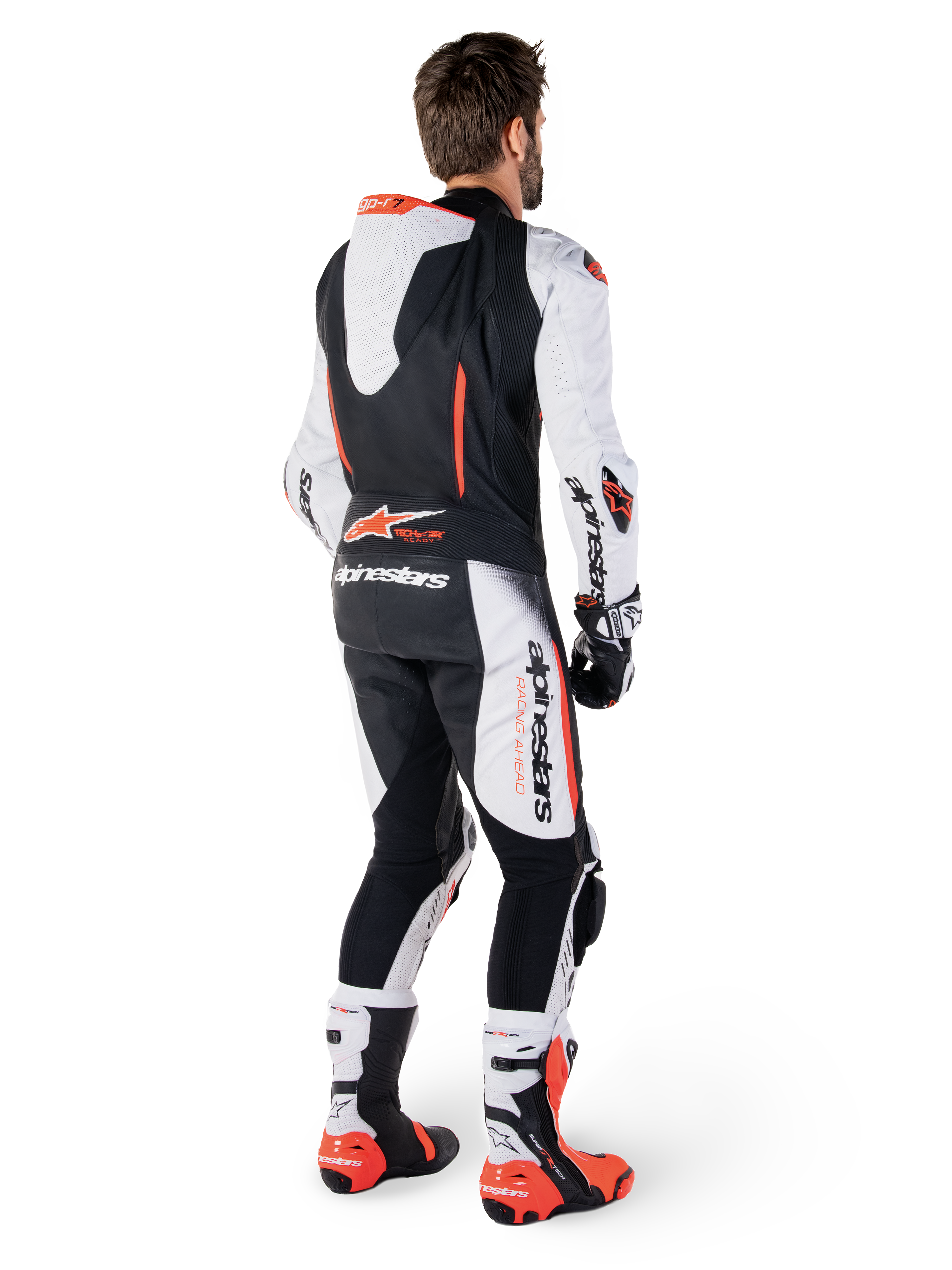 Alpinestars GP-R7, combinaison en cuir de course pour homme, blanche et noire, avec bosse aérodynamique, Tech-Air ready, vue de dos sur un pilote avec bottes et gants professionnels.
