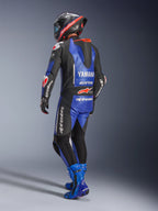 Alpinestars Yamaha GP-R7 One Piece Leather Suit, Metallic Blue Black and White, Rear view showing aerodynamic race hump and Yamaha branding, worn with matching blue racing boots and helmet, professional performance leather suit for track racing