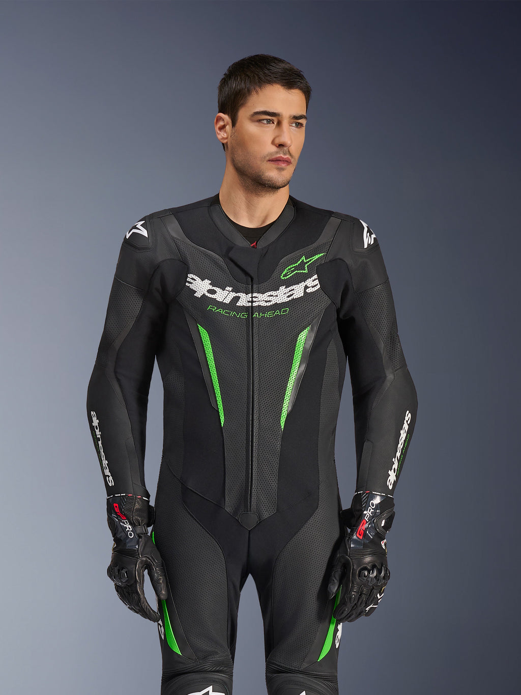 Combinaison en cuir Alpinestars GP Force V2 - 1 pièce, combinaison de moto noire et verte, portée par un mannequin, avec panneaux en cuir perforé, logo Alpinestars blanc sur la poitrine et les manches, et protection d'épaule intégrée pour la performance sur circuit.