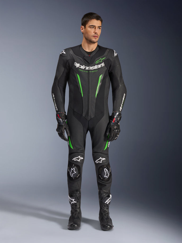 Alpinestars GP Force V2 Leather Suit - 1Piece, One-Piece Motorcycle Racing Suit, Black and Green, front view of a model wearing the suit with white branding on the chest and neon green accents, featuring perforated leather and external shoulder sliders, paired with black racing gloves and boots